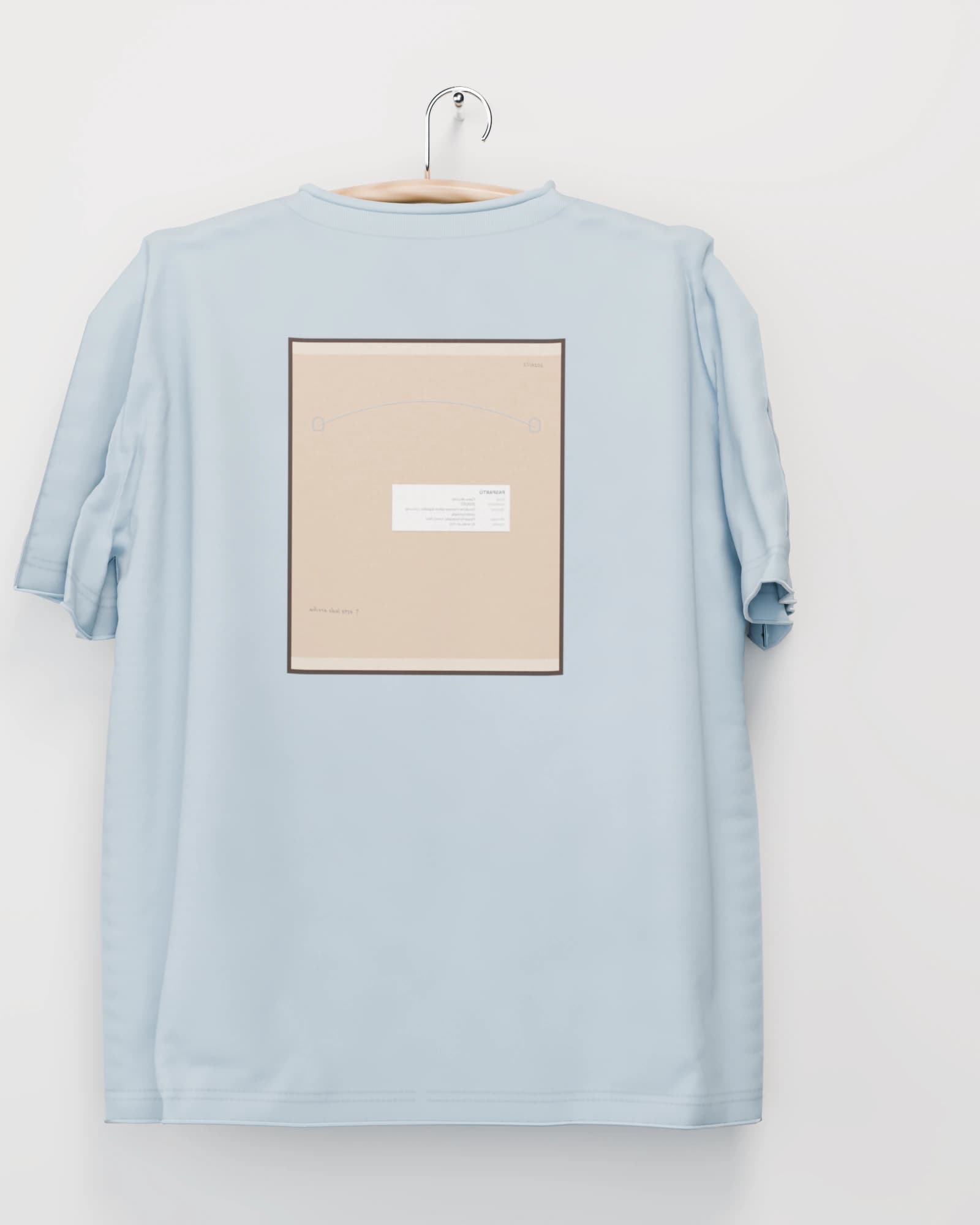 Polera color azul glaciar vista por detrás, la espalda con el reverso de la obra estampado: el respaldo de papel kraft con su alambre y su etiqueta de inventario