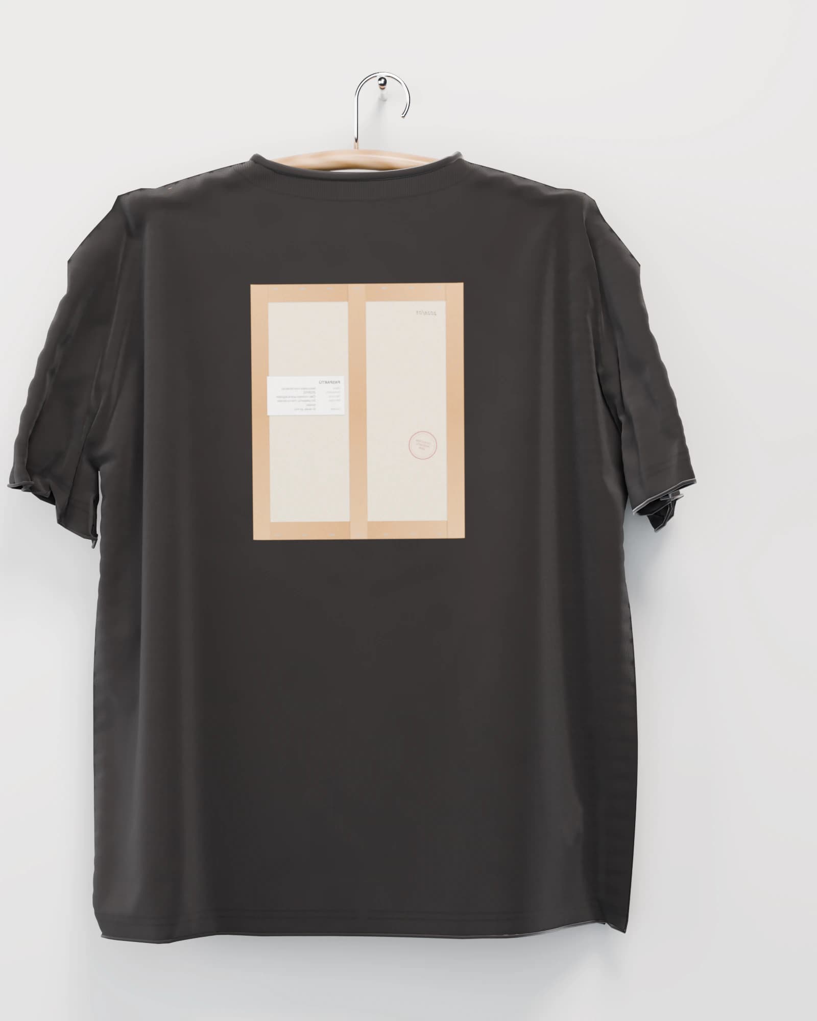 Polera color negro lavado vista por detrás, la espalda con el reverso de la obra estampado: el respaldo de papel kraft con su alambre y su etiqueta de inventario